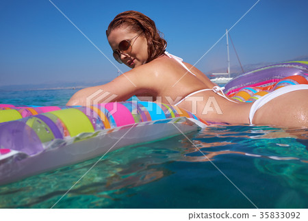 Summer travel. Vacation. Woman hanging out on air mattress. With 35833092