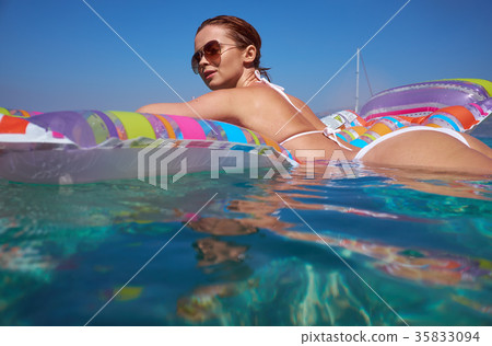 Summer travel. Vacation. Woman hanging out on air mattress. With 35833094