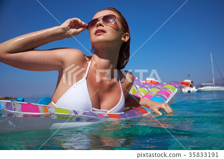 Summer travel. Vacation. Woman hanging out on air mattress. With Summer travel. Vacation. Woman hanging out on air mattress. With 35833191
