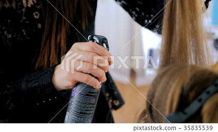 Professional hairdresser doing hairstyle for young Professional hairdresser doing hairstyle for young 35835539