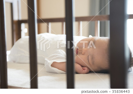Baby sleeping in a cot 35836443