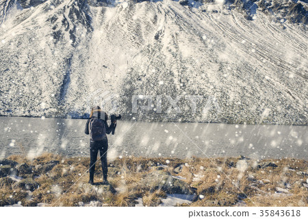 A woman photographer with camera on lake in Swis 35843618