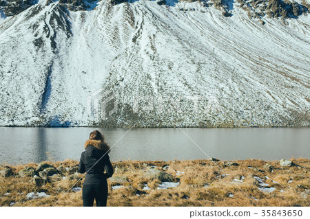 A woman photographer with camera on lake in Switze 35843650