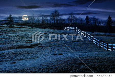 fence on grassy hillside in autumn at night 35848838