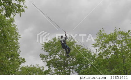 Man descends on a rope between the trees 35851451