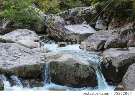 A mountain stream with a large rock 35862994