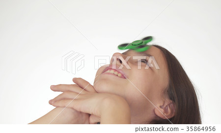 Beautiful cheerful teen girl spinning a green 35864956