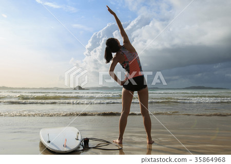 woman surfer warming up on a beach 35864968