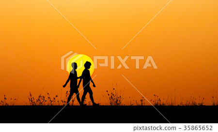 Silhouette Boy And Girl Walking Together At Sunset Stock Photo