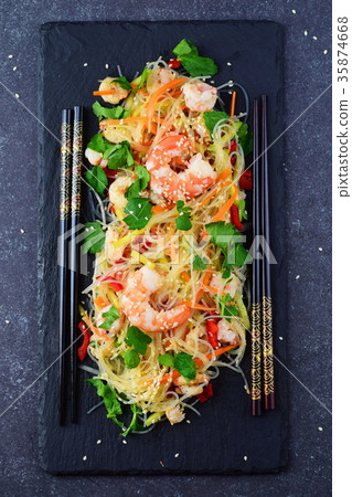Noodles with prawns and vegetables on black slate Noodles with prawns and vegetables on black slate 35874668