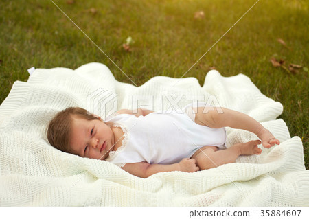 Baby lying on the blanket on the grass Baby lying on the blanket on the grass 35884607