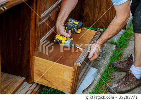 workman fixing cabinet with screwdriver kitchen 35885771