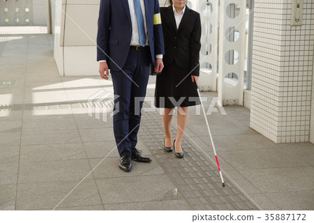 Woman in recruit suit using white cane 35887172