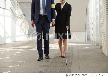 Woman in recruit suit using white cane 35887173