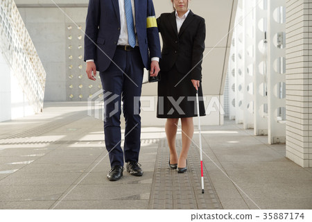 Woman in recruit suit using white cane 35887174