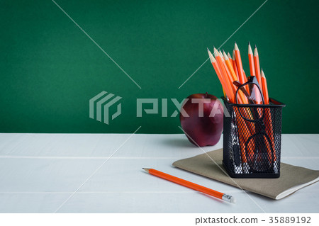Books Pencil and apple on a white wooden table 35889192