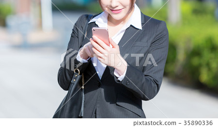 在衣服的婦女的手與智能手機OL西裝畫象Recruit綠色背景 在衣服的婦女的手與智能手機OL西裝畫象Recruit綠色背景 35890336