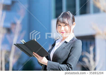 婦女OL西裝畫象衣服招聘與衣服的綠色背景 婦女OL西裝畫象衣服招聘與衣服的綠色背景 35891204