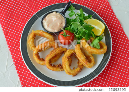 Calamari rings fried with spicy sauce. Calamari rings fried with spicy sauce. 35892295