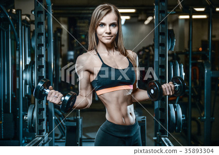 Sexy athletic young girl training arms in gym 35893304