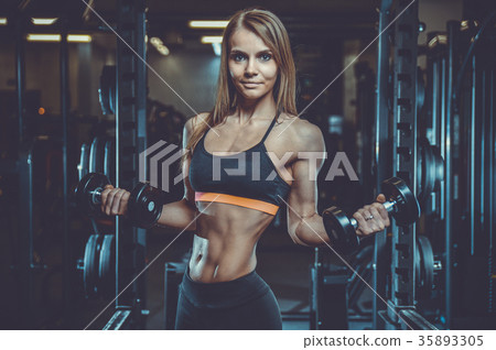 Sexy athletic young girl training arms in gym 35893305