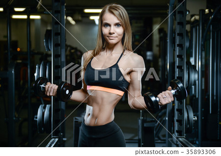 Sexy athletic young girl training arms in gym 35893306