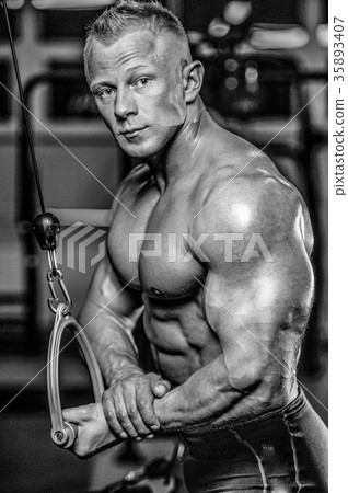 Handsome model young man training arms in gym 35893407