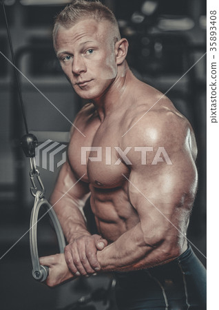 Handsome model young man training arms in gym 35893408