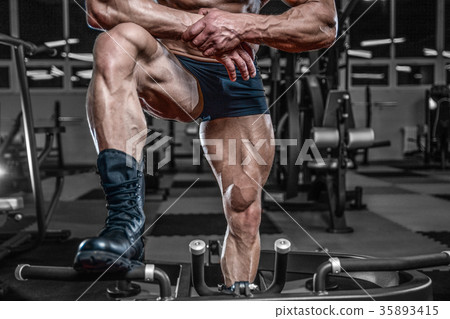 Handsome model young man training legs in gym Handsome model young man training legs in gym 35893415