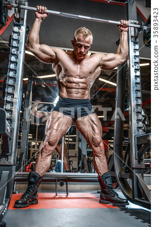 Handsome model young man training legs in gym 35893423