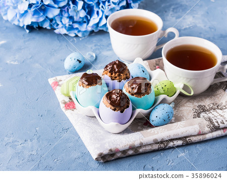 Easter sweet cup cakes treets in egg shell on blue 35896024
