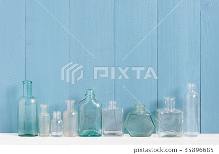 Blue wooden background with empty various bottles Blue wooden background with empty various bottles 35896685
