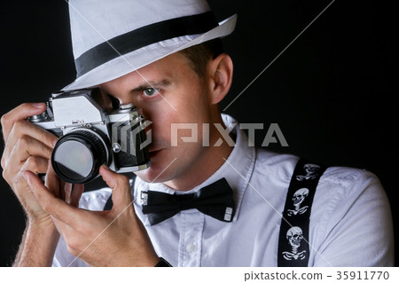 Young stylish man with photo camera Young stylish man with photo camera 35911770