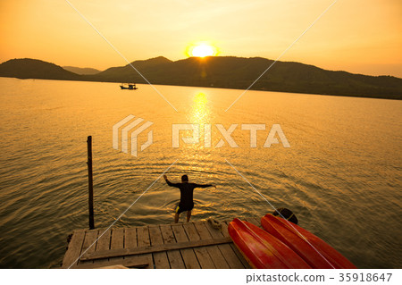 The boy jumping in sae at early evening. The boy jumping in sae at early evening. 35918647