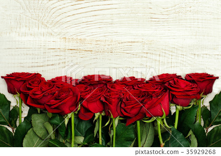 圖庫照片: red roses on a light wooden background, top view