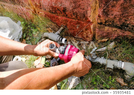 Plumber installing outdoor valve meter piping 35935481