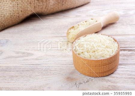 Rice in a bowl on wooden background Rice in a bowl on wooden background 35935993