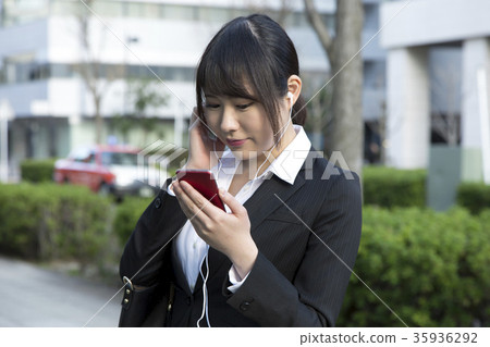 Female office worker business woman listening to music Female office worker business woman listening to music 35936292