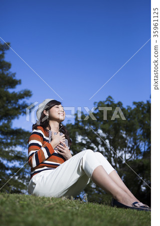 Woman enjoying reading in the park Woman enjoying reading in the park 35961125