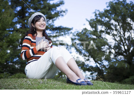 享受讀在公園的婦女 享受讀在公園的婦女 35961127