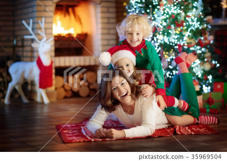 Family with kids at Christmas tree and fireplace. 35969504
