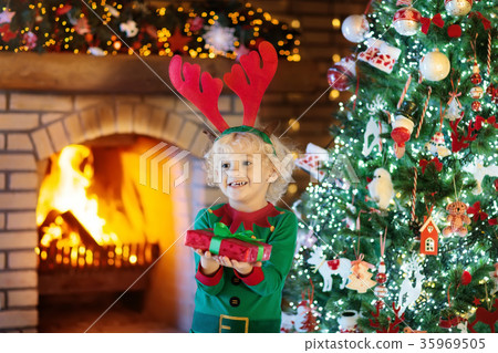 Child at Christmas tree and fireplace on Xmas eve Child at Christmas tree and fireplace on Xmas eve 35969505