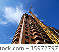 Construction crane near building on blue sky 35972797