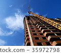 Construction crane near building on blue sky 35972798