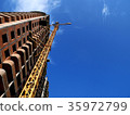 Construction crane near building on blue sky 35972799