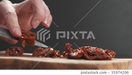 closeup man slicing sundried tomatoes closeup man slicing sundried tomatoes 35974206