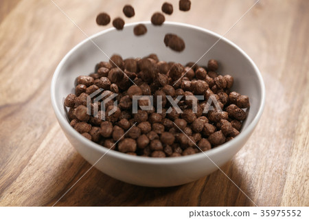chocolate cereal balls fall in white bowl for 35975552