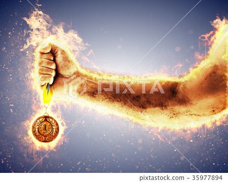 Man's hand in a fire is holding gold medal. Winner 35977894