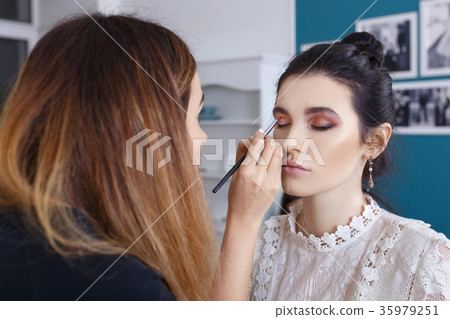 makeup artist applying shadows on the eyelid 35979251