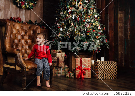 Surprised excited girl in an armchair against the Surprised excited girl in an armchair against the 35982232